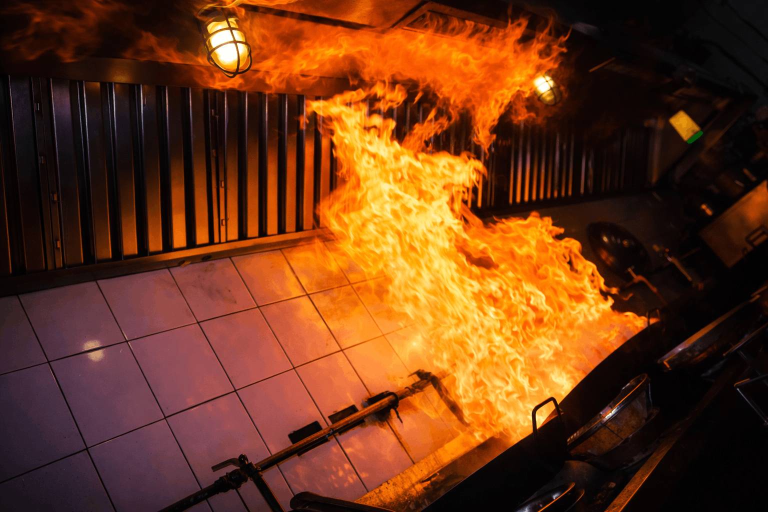 Commercial kitchen grease fire inside restaurant hood system caused by grease buildup in exhaust ventilation