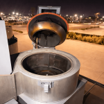 Opened rooftop upblast exhaust fan with hinged access for commercial kitchen exhaust inspection and cleaning